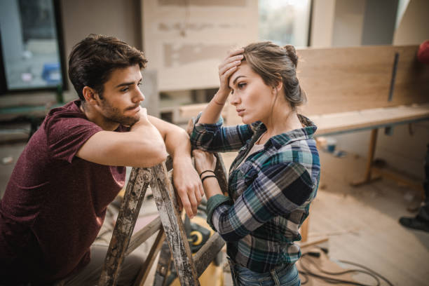 Worried couple standing on ladders and thinking the easiest way possible for home renovation.